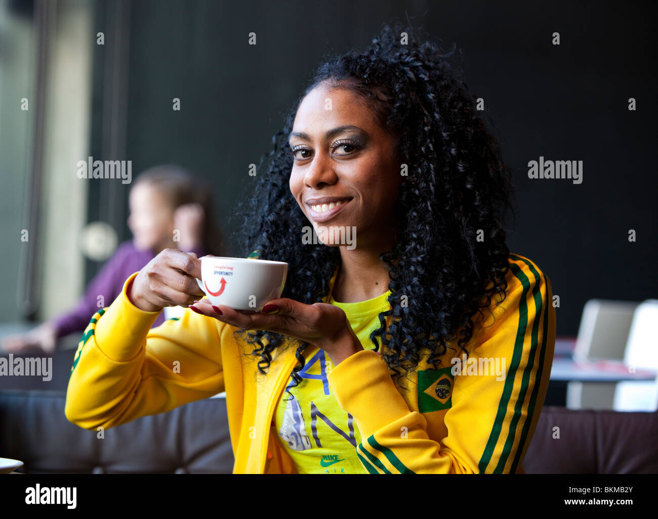 Headshot ritratto di una donna cubana di bere una tazza di caffè, London, England, Regno Unito Foto Stock