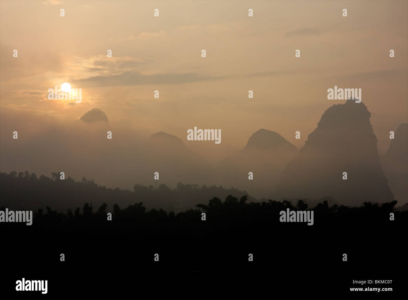 Distintivo colline calcaree nella nebbia al sorgere del sole nei pressi di Yangshuo, regione di Guangxi, Cina Foto Stock