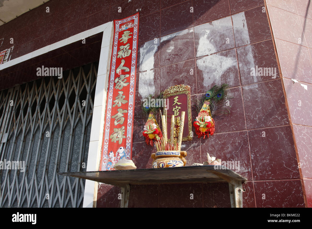 Un piccolo santuario cinese al di fuori di una casa in Kampot, Cambogia. Foto Stock