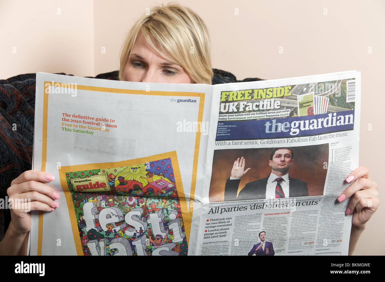 Donna leggendo una copia del quotidiano Guardian Foto Stock