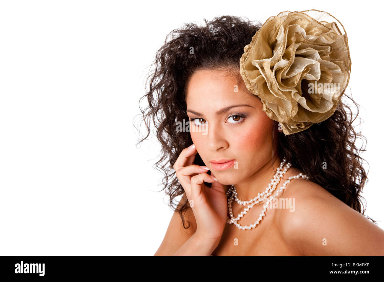 Bella faccia di un caucasico donna ispanica con pelle chiara, indossa una collana di perle e un falso fiore nei capelli ricci, isolato Foto Stock