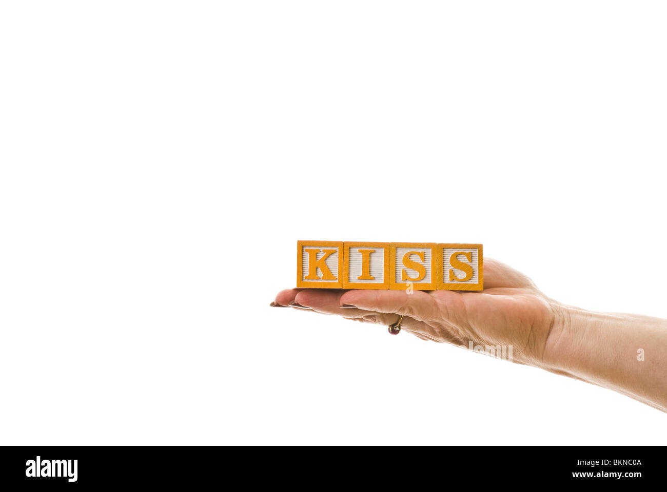 Donna che mantiene i bambini i blocchi che scrivi "kiss" Foto Stock