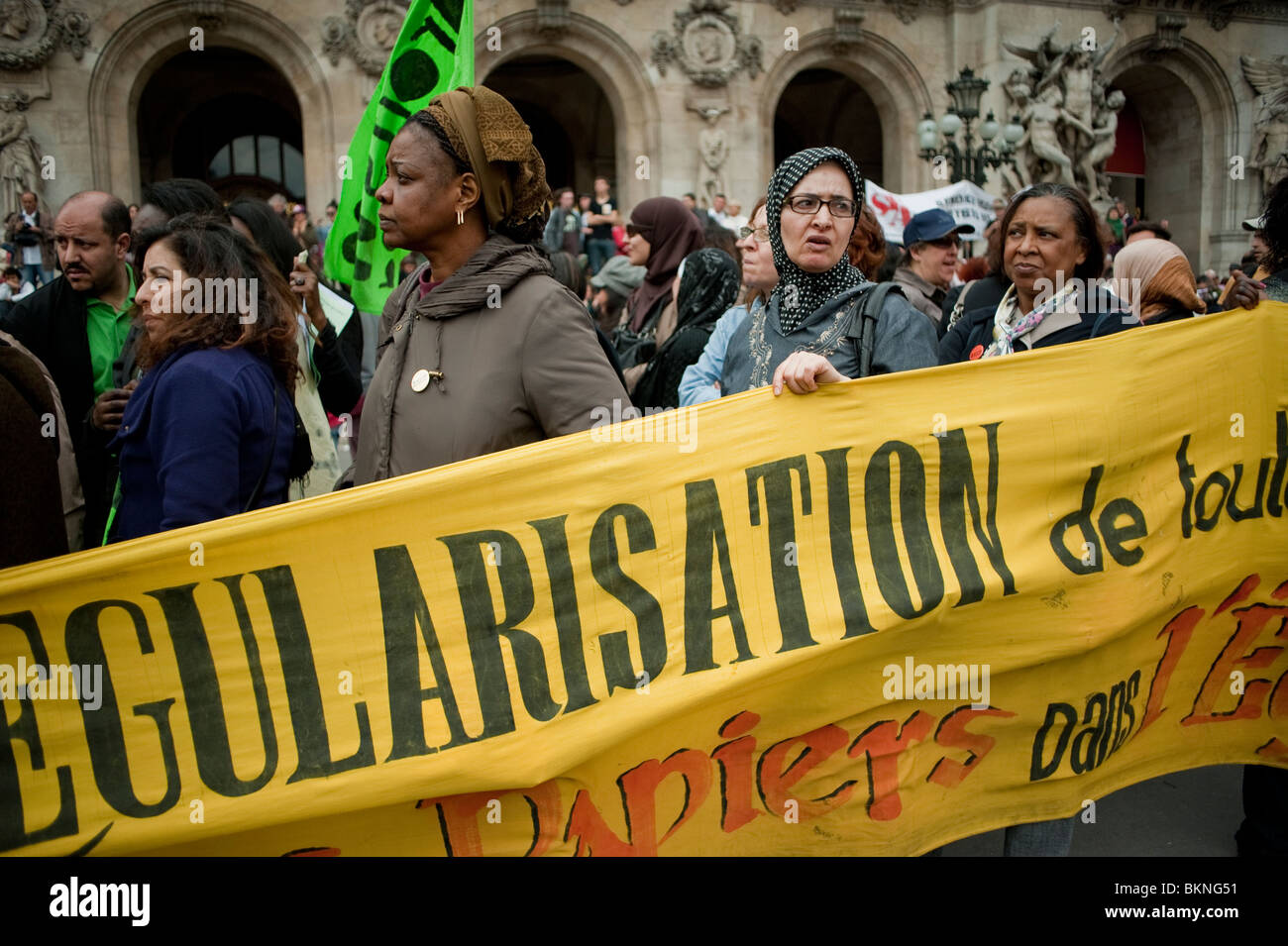 Folla di donne migranti, immigrati, Sans Papiers che dimostrano nel maggio 1, maggio giorno dimostrazione, Parigi, Francia, Holding protesta Banner on Street, manifestanti multirazziale diritti umani, persone non documentate, proteste per i diritti dei lavoratori Foto Stock