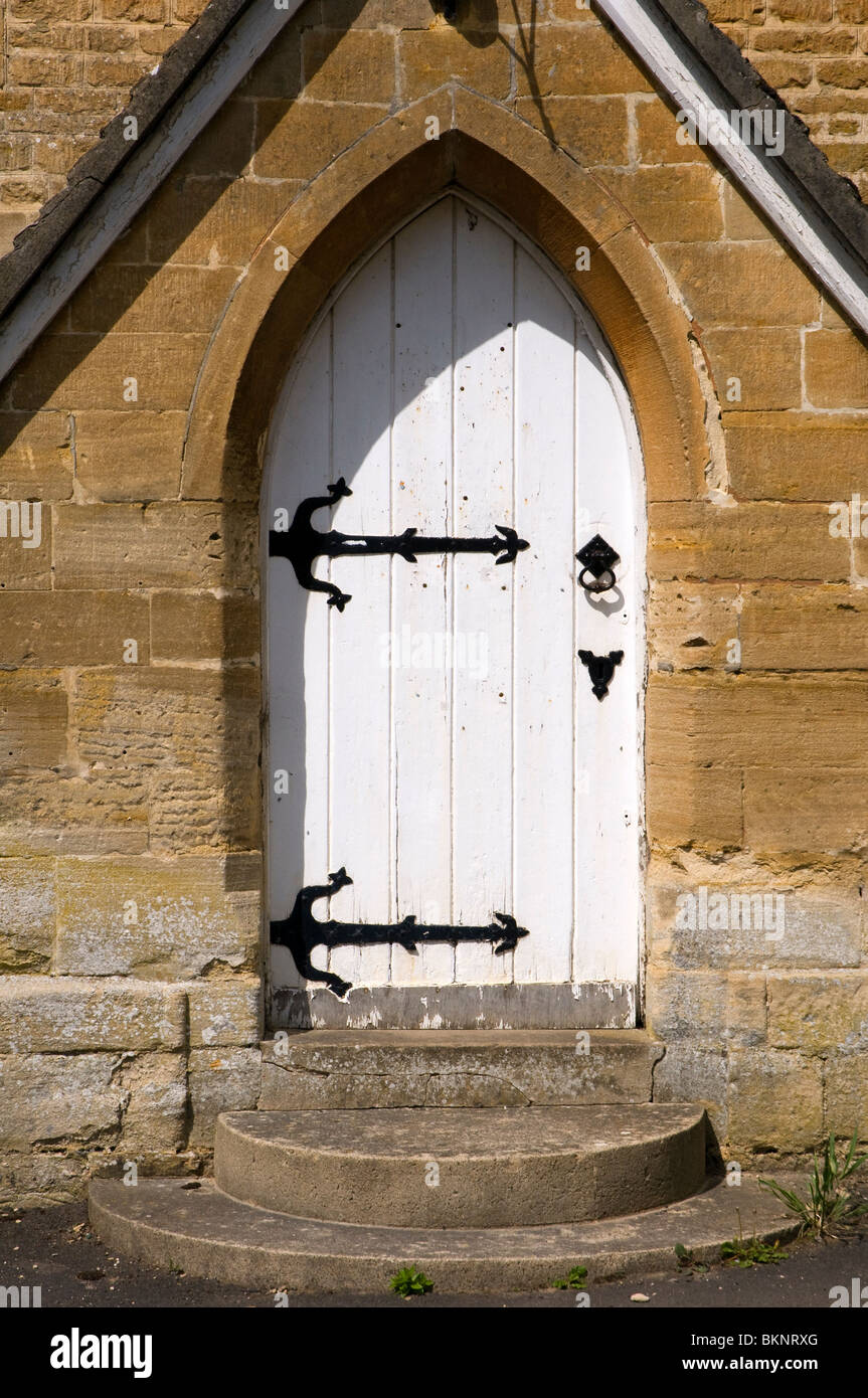 Una chiesa bianca porta con black metal strap cerniere in corrispondenza Glympton in West Oxfordshire. Foto Stock