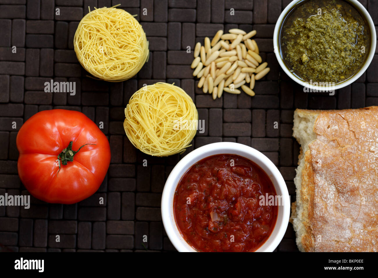 In italiano o in stile mediterraneo di cottura Ingredienti inclusi Vermicelli nidi, pomodoro rosso e verde Pesto bianco pane croccante e pinoli Foto Stock