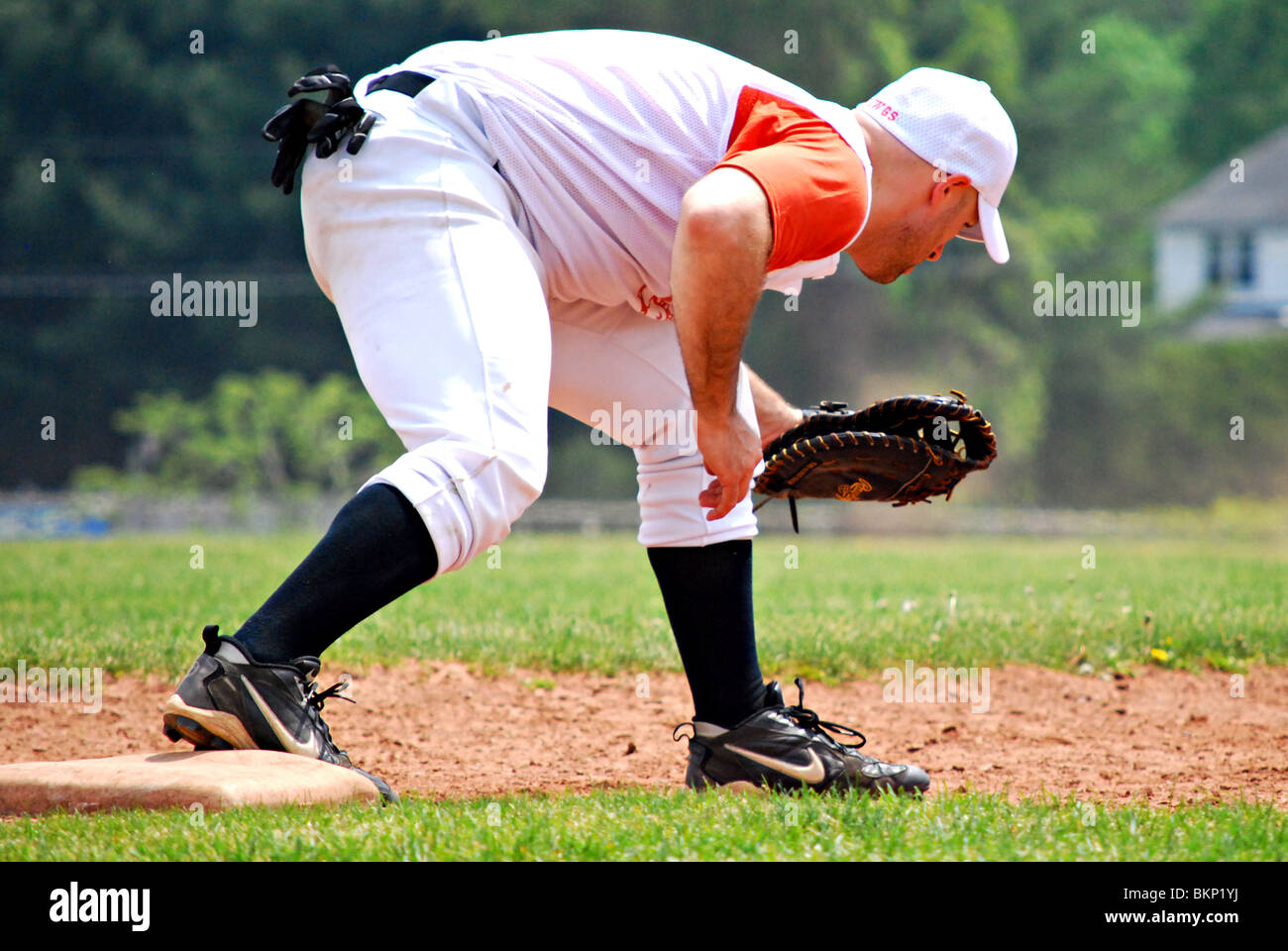 Mens baseball league. primo baseman tenta di ottenere il runner fuori sulla prima base. Foto Stock