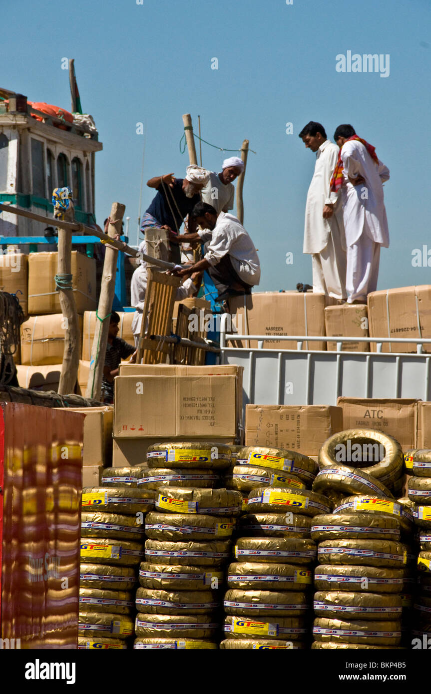 I lavoratori stranieri in Sharjah porta barca di caricamento Foto Stock