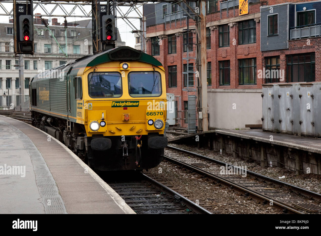 Una classe 66 treno merci in esecuzione senza camion attraverso Manchester Oxford Road Station Foto Stock
