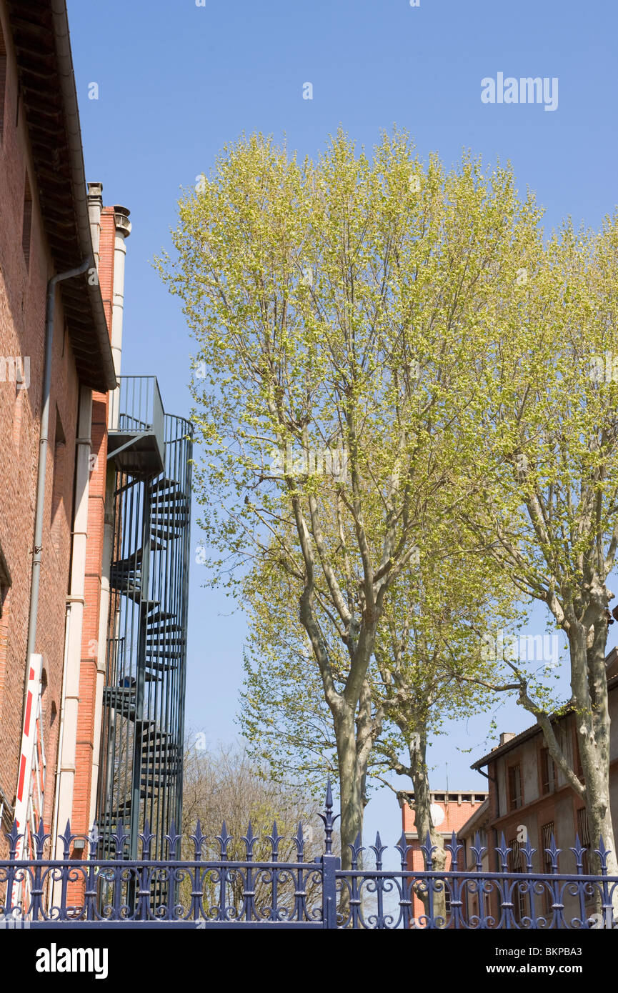 Eterna Ferro Battuto spirale fire escape con ringhiere di sicurezza attaccato ad un edificio in Toulouse Haute Garonne Midi-Pirenei Foto Stock