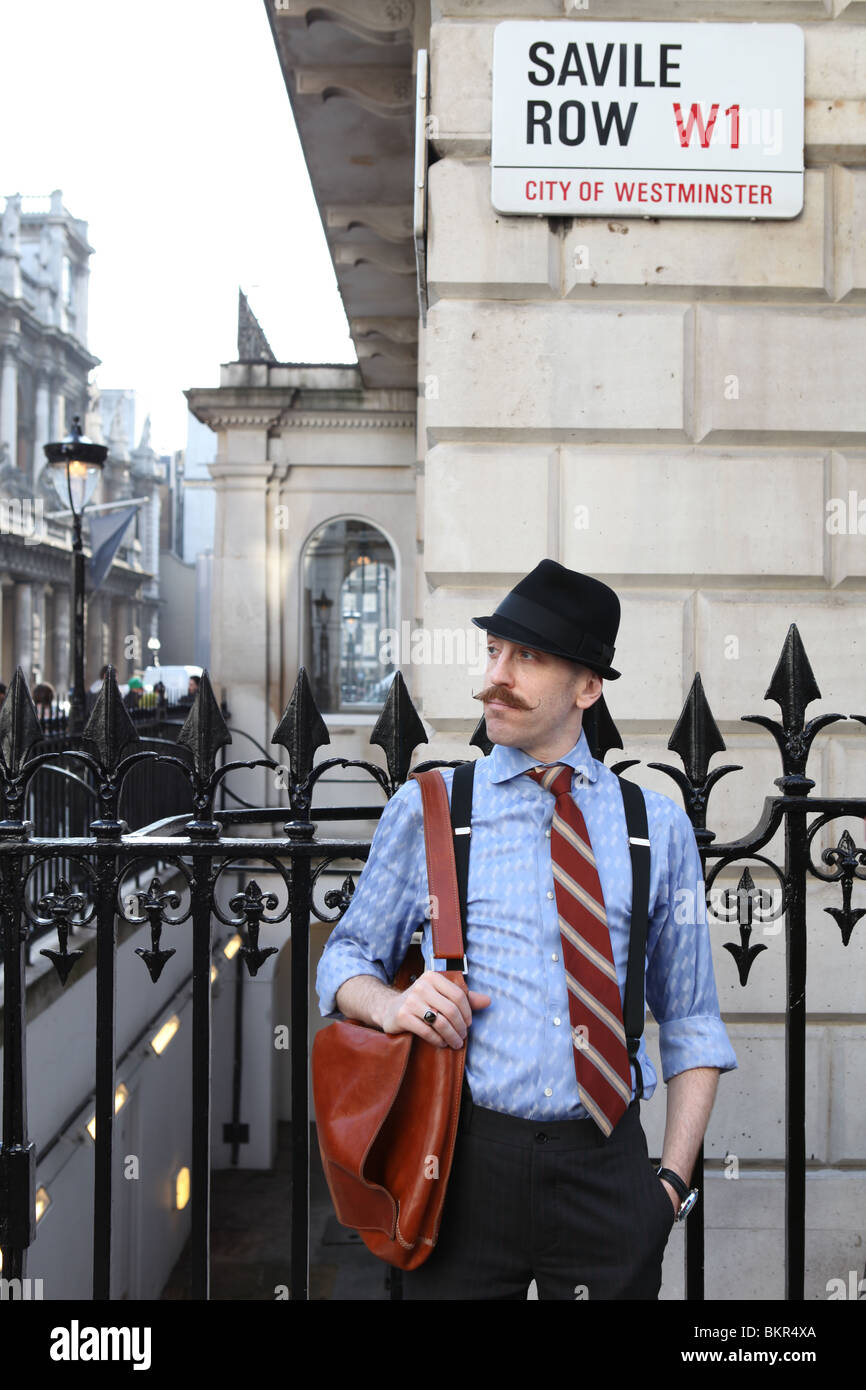 Un uomo si erge in Savile Row London. Foto Stock