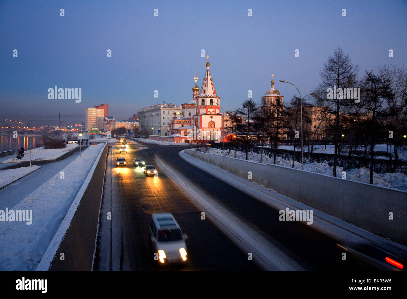 La Russia, Siberia, Irkutsk; una chiesa ortodossa vicino al fiume Angara e vetture passando rapidamente dalla. Foto Stock