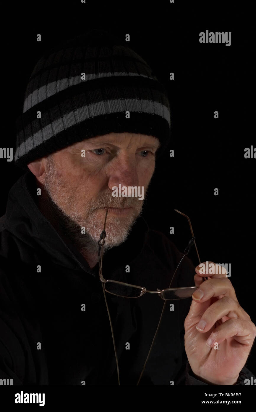 Uomo maturo vestita di nero profondo nel pensiero. Isolato. Foto Stock