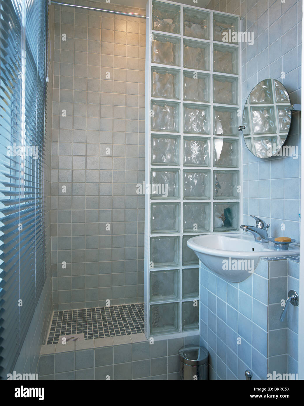 Mattone di vetro parete doccia in piccolo e moderno bagno rivestito di  piastrelle con montati a parete basin Foto stock - Alamy