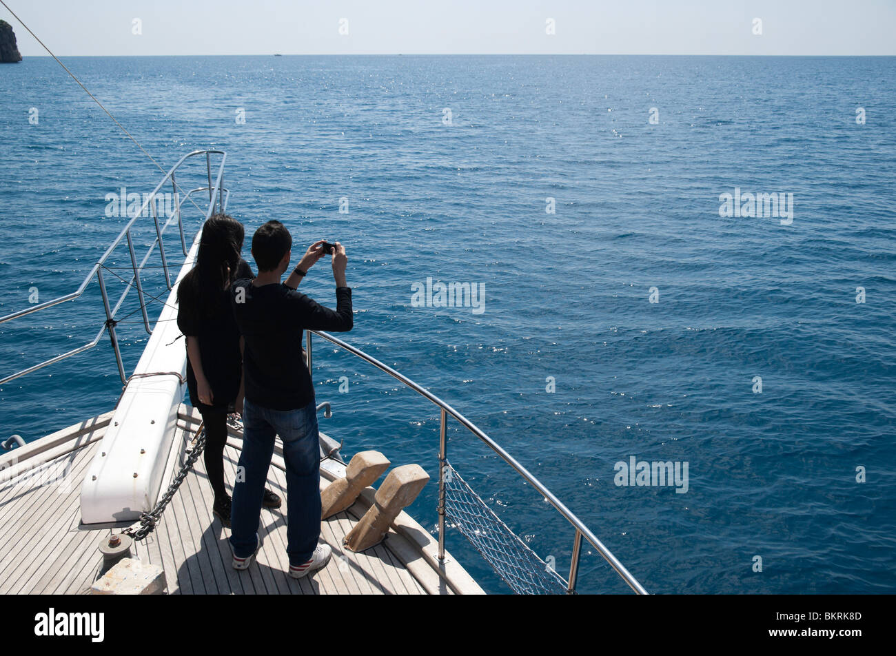 Giovani turche giovane su un viaggio in barca - utilizzando un telefono cellulare dotato di fotocamera digitale Foto Stock