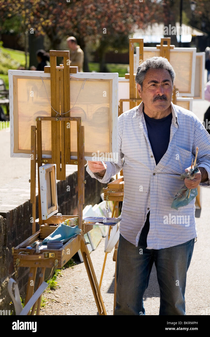 Artista / pittore dipinge un dipinto di Richmond bridge - dal riverside; sarà per per la vendita ai turisti. Richmond. Regno Unito. Foto Stock