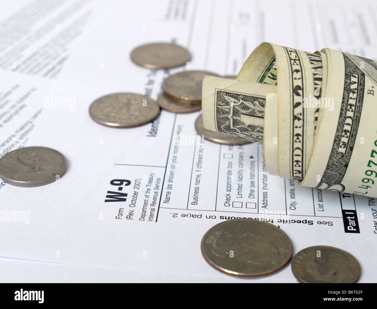 Borra in dollari americani e monete su W-9 imposta sul reddito forme Foto Stock