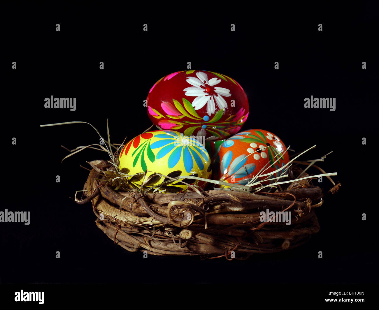 Dipinto di uova di Pasqua nel nido su sfondo nero Foto Stock