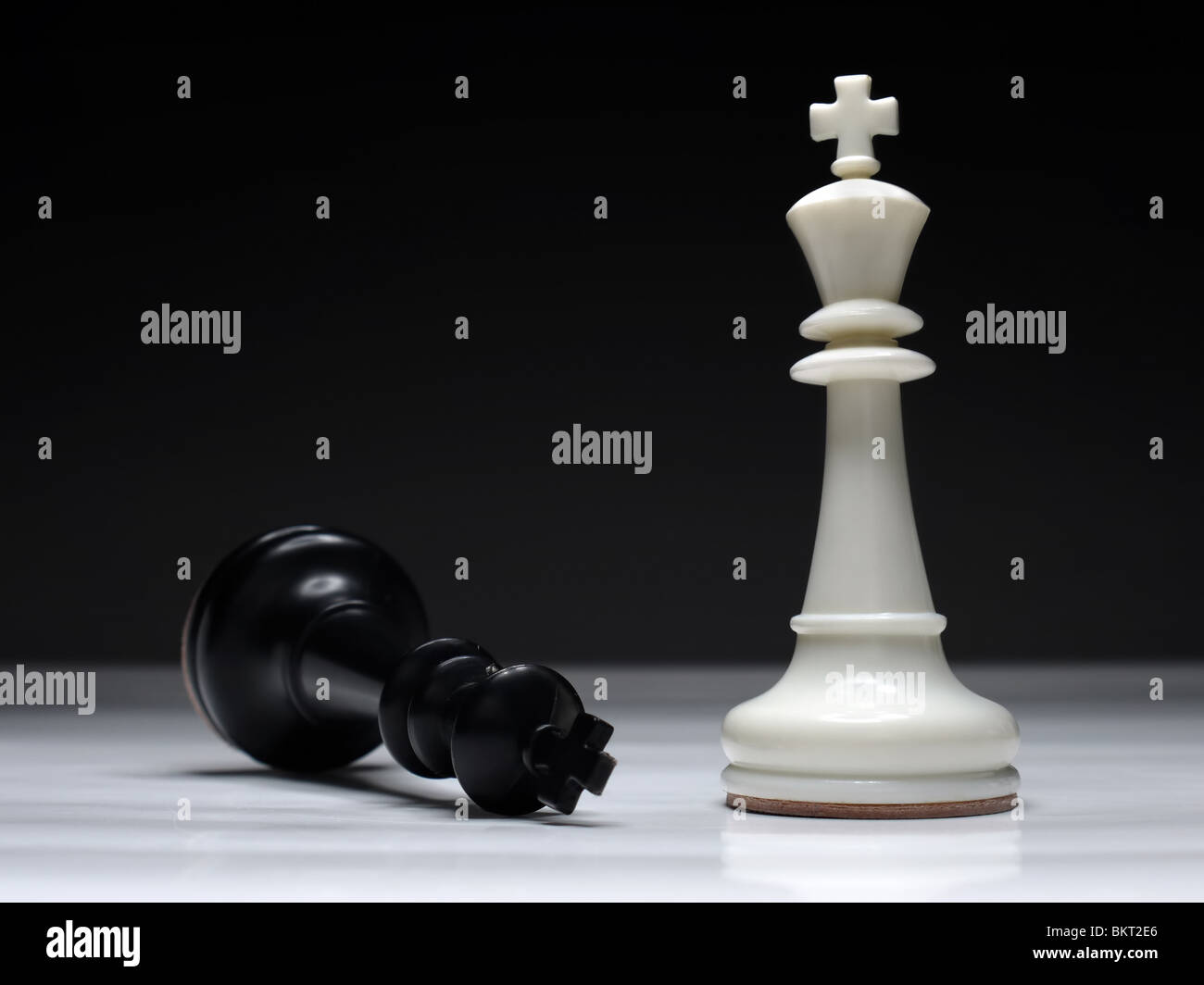 Re Nero giacente sulla scacchiera da vincente il re bianco Foto Stock