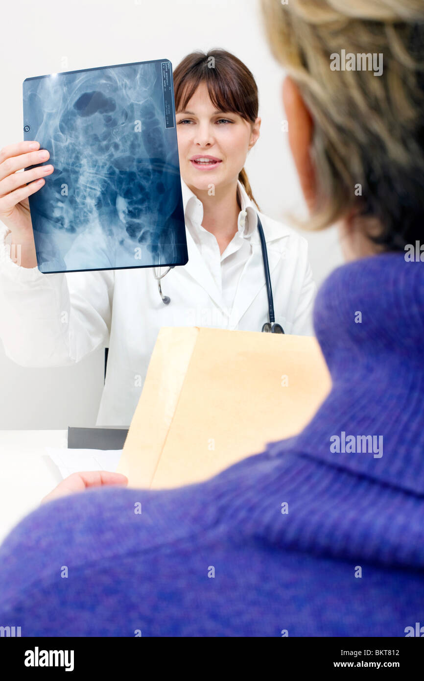 Paziente e medico donna esaminando un X-ray Foto Stock