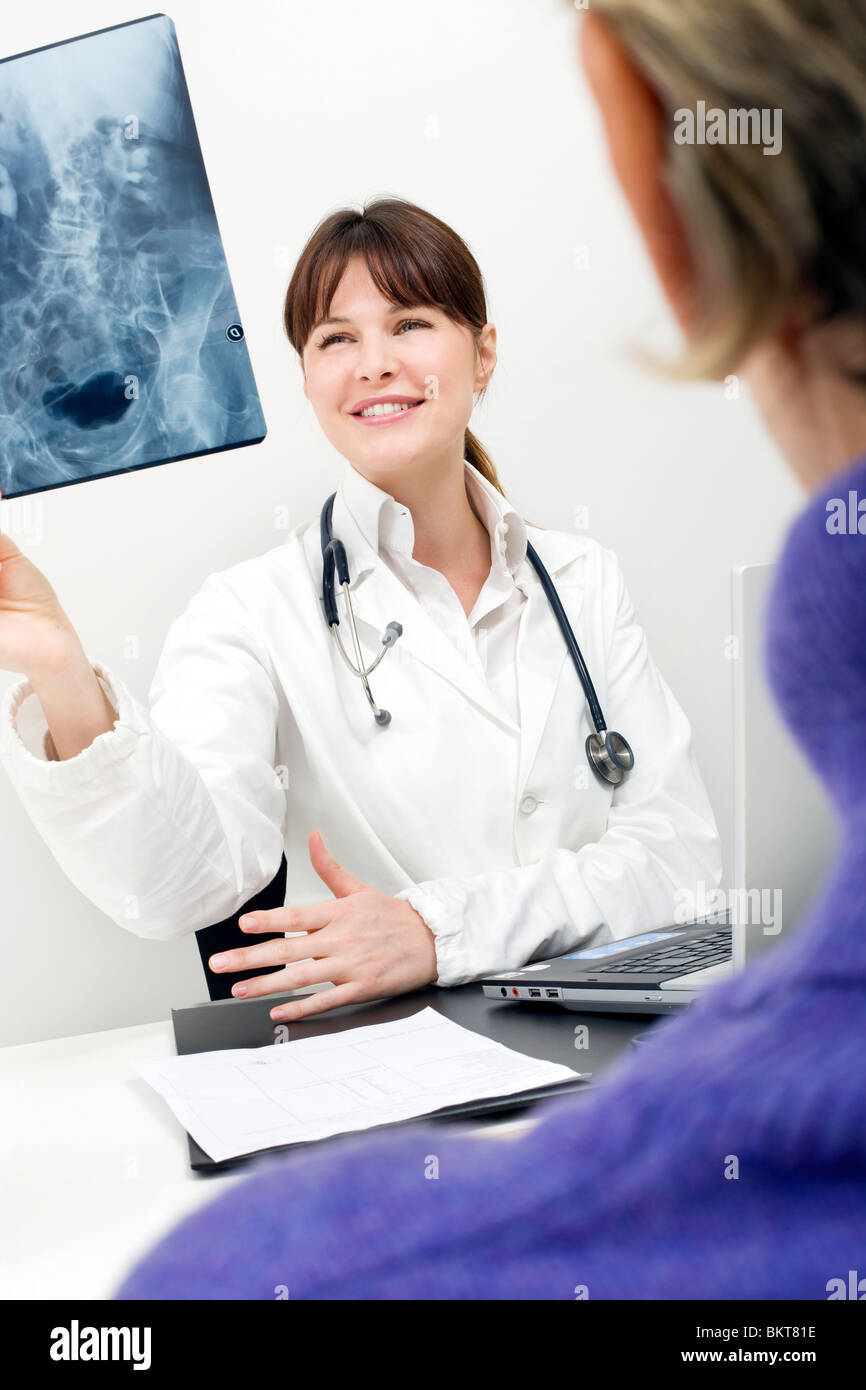 Paziente e medico donna esaminando un X-ray Foto Stock