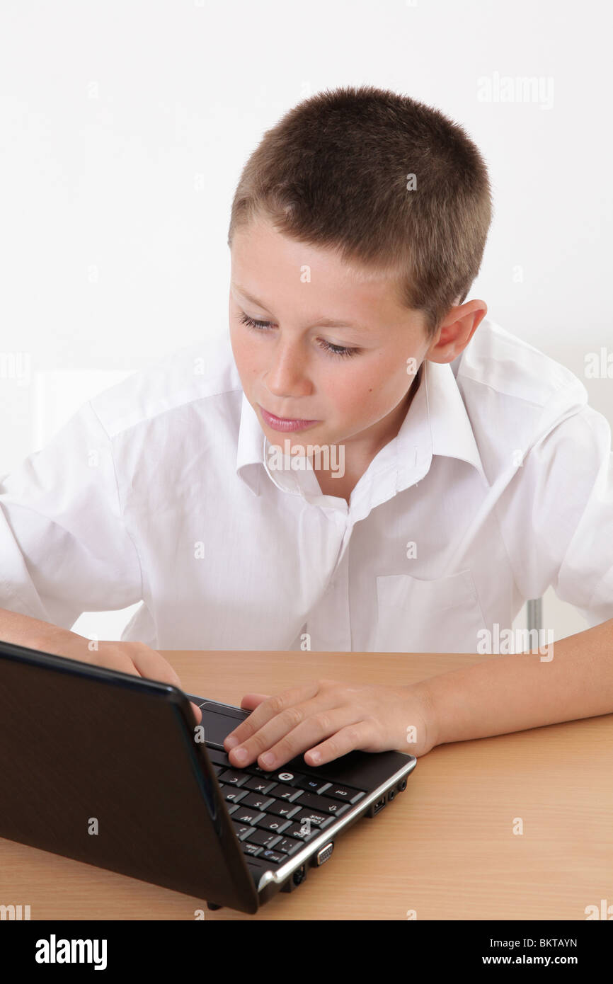 Ragazzo giovane usando un computer portatile Foto Stock