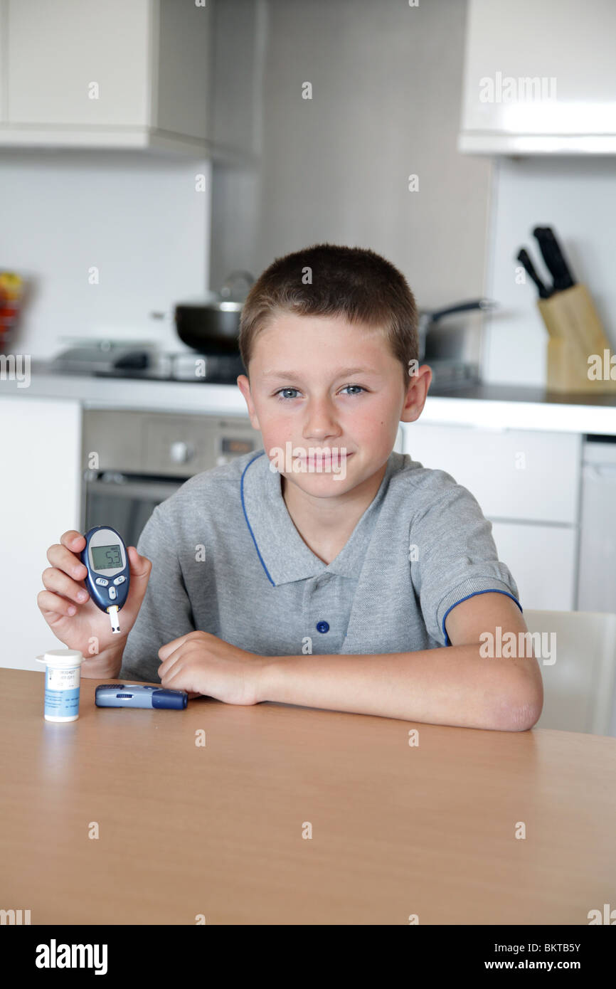 Giovane ragazzo facendo un livello di glucosio nel sangue il test Foto Stock
