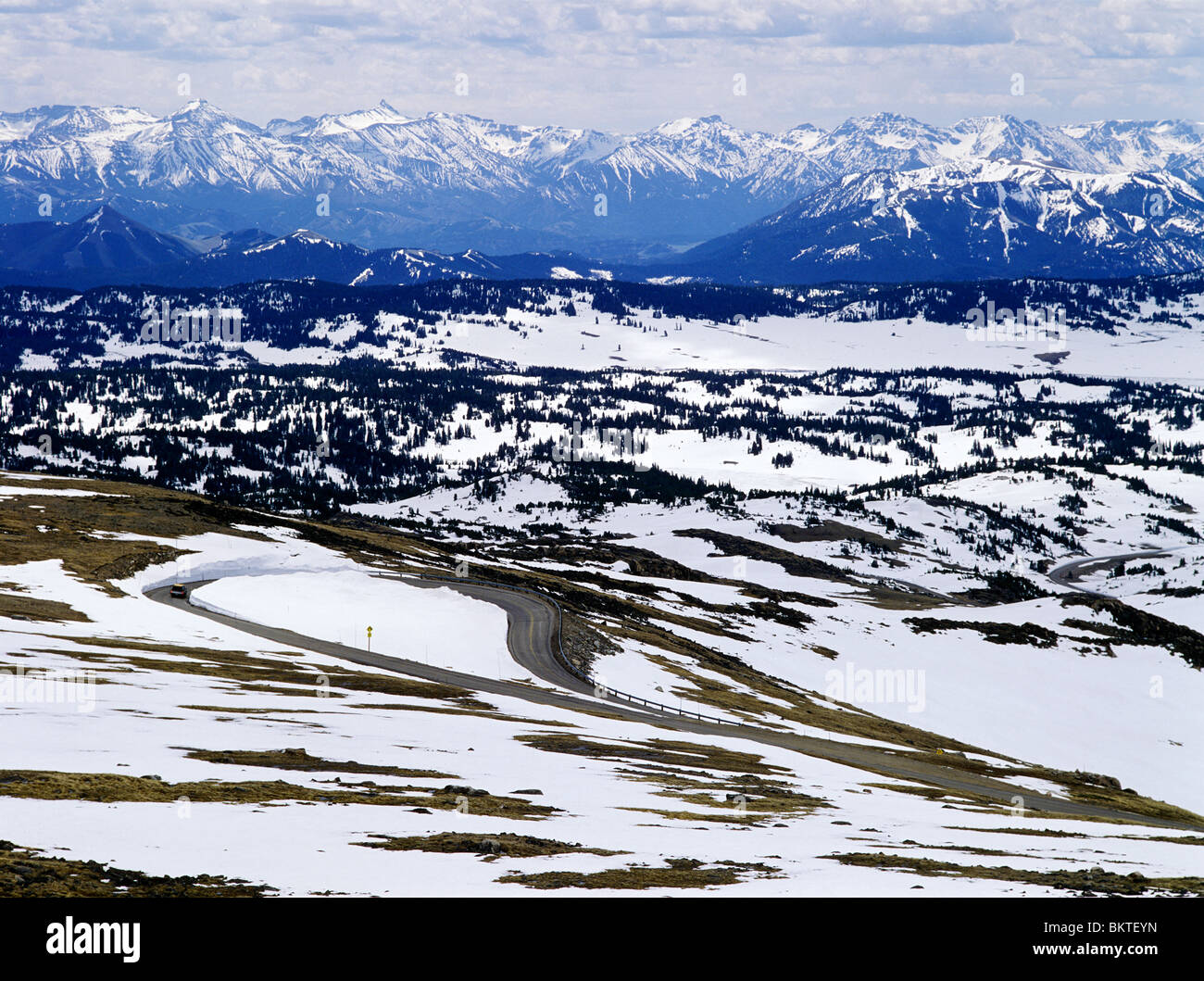 Auto sulla curva di U.S. Route 212, Beartooth Highway, oltre la Beartooth Mountains, all'inizio della primavera, Montana USA Foto Stock