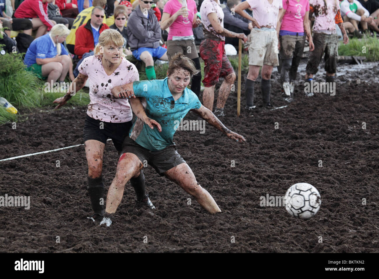 SWAMP SOCCER, SPORT ESTREMI, DUELLO FEMMINILE: Due donne bagnate di fango combattono per il pallone alla 13a edizione della Coppa del mondo annuale di calcio Swamp Soccer a Ukkohalla, Finlandia Foto Stock