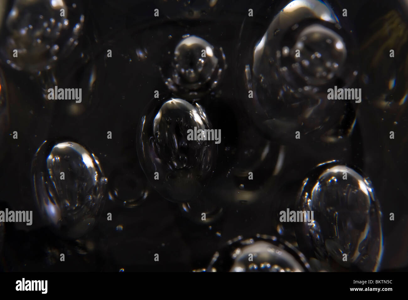 Macro di bolle di vetro su uno sfondo nero Foto Stock