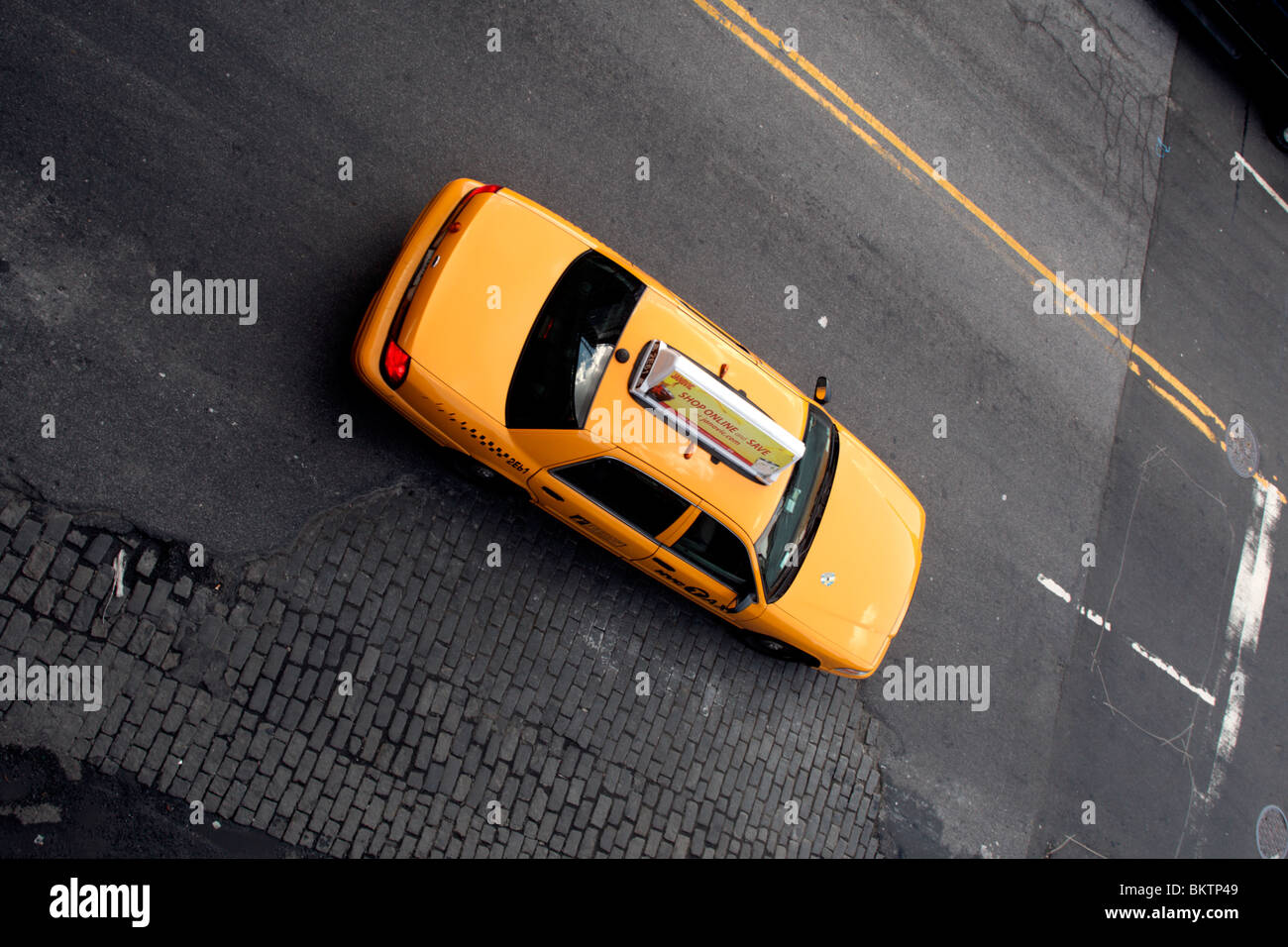 New York City taxi, top vista obliqua su nero strada macadam Foto Stock