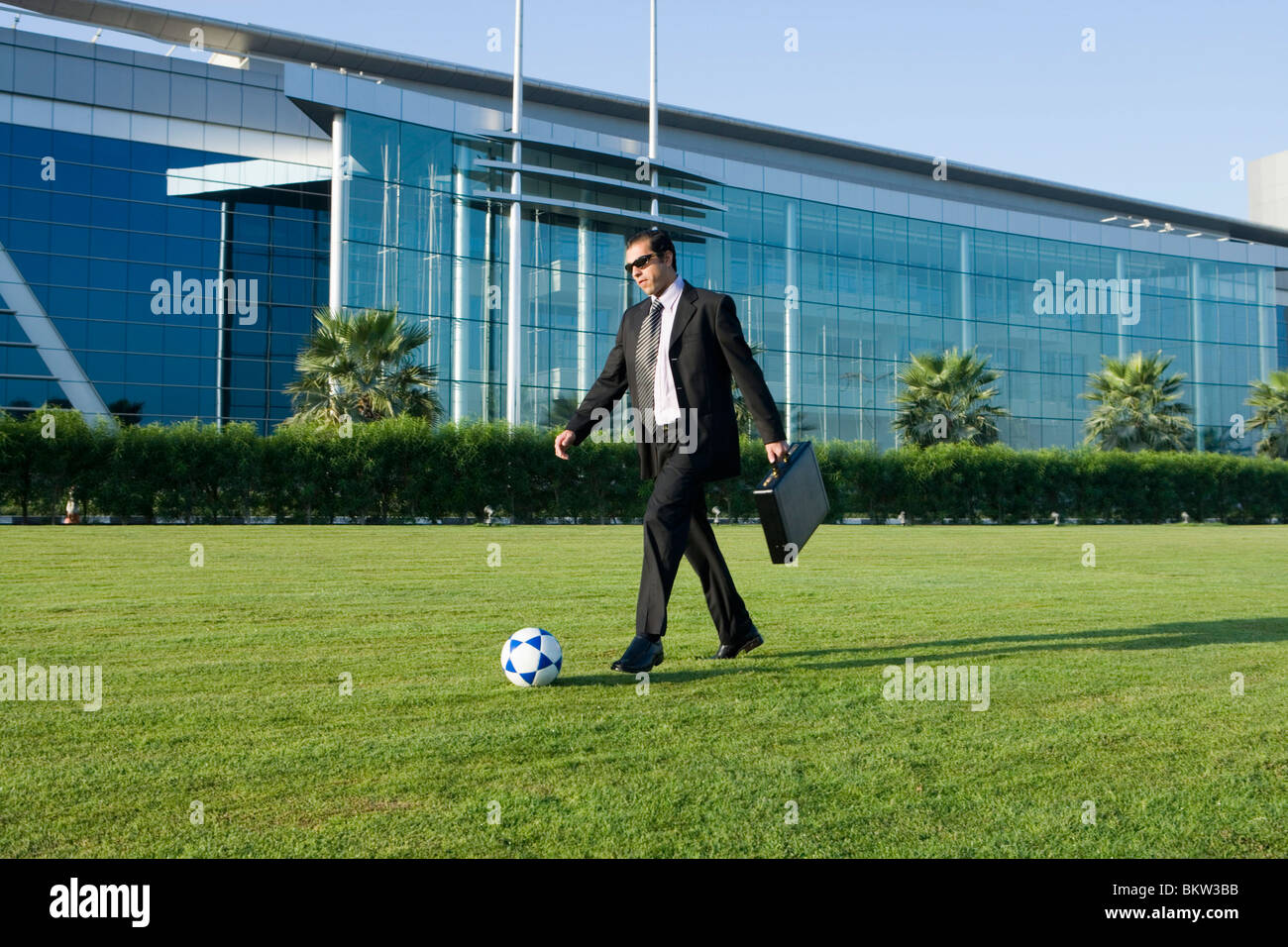 Imprenditore giocando con il calcio Foto Stock