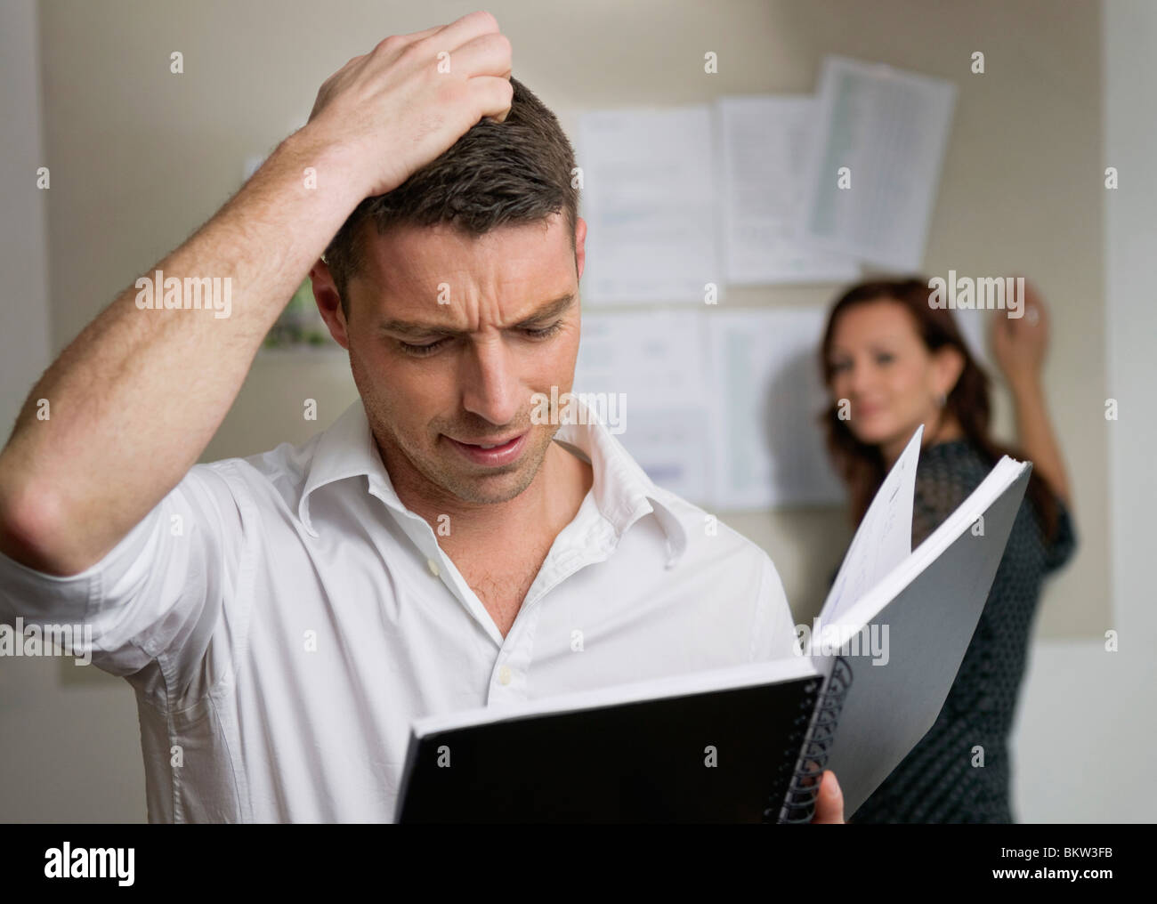 Uomo tormentato con i notebook in ufficio Foto Stock