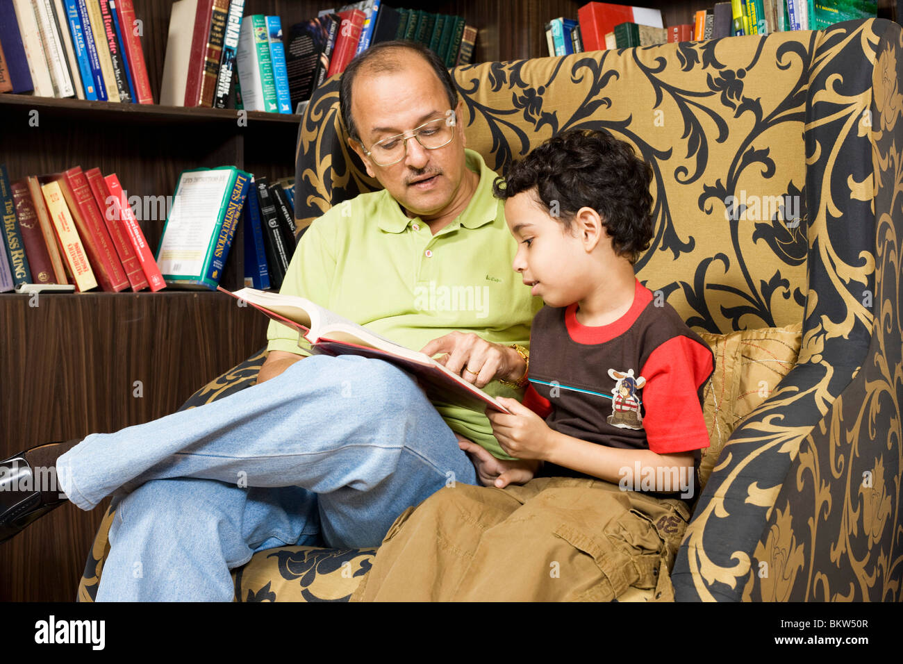 Il nonno con il nipote la lettura di un libro delle fiabe Foto Stock