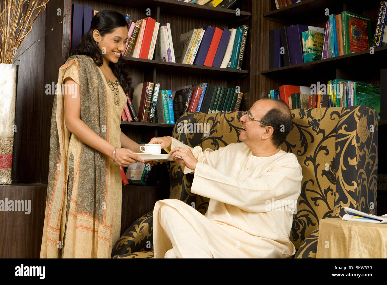 Figlia di servire il tè a suo padre Foto Stock
