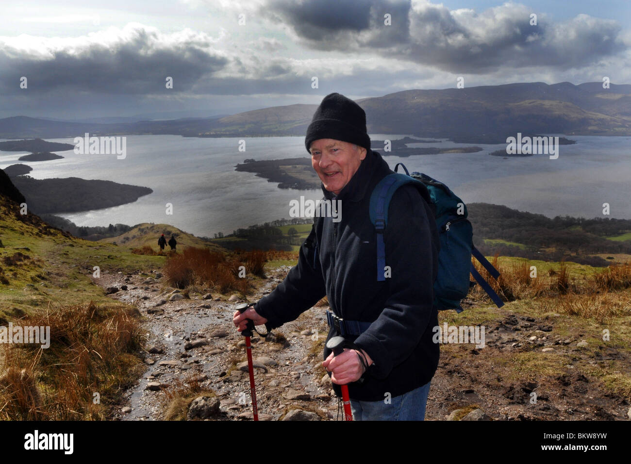 Persone anziane attive andare passeggiate in collina nel Trossachs National Park, Scozia Foto Stock