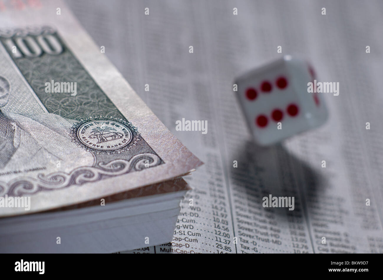 Bundle di rupia indiana di banconote con un dado sulla parte superiore della sezione business un giornale Foto Stock