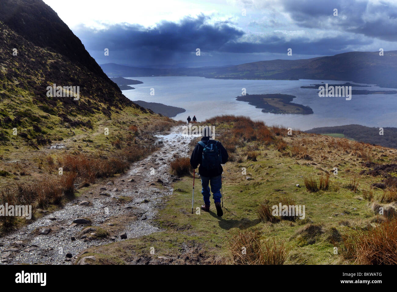 Persone anziane attive andare passeggiate in collina nel Trossachs National Park, Scozia Foto Stock