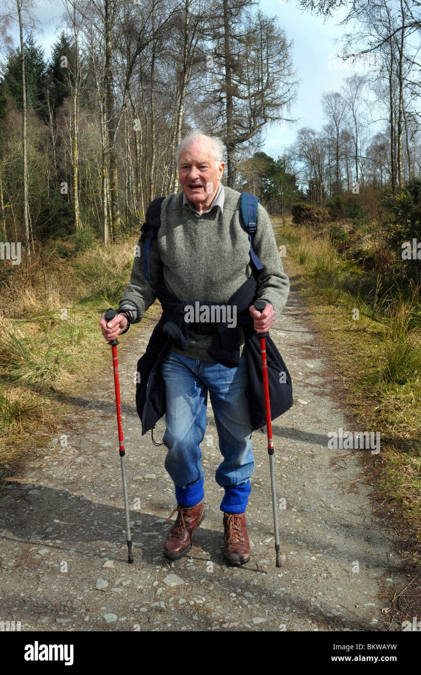 Persone anziane attive andare passeggiate in collina nel Trossachs National Park, Scozia Foto Stock