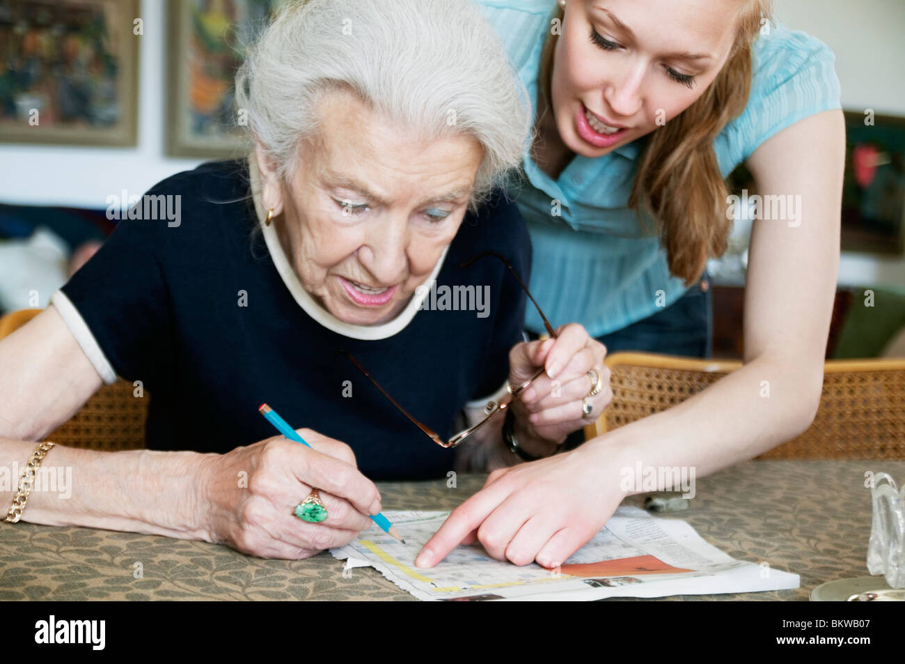 Due donne risoluzione cruciverba insieme Foto Stock