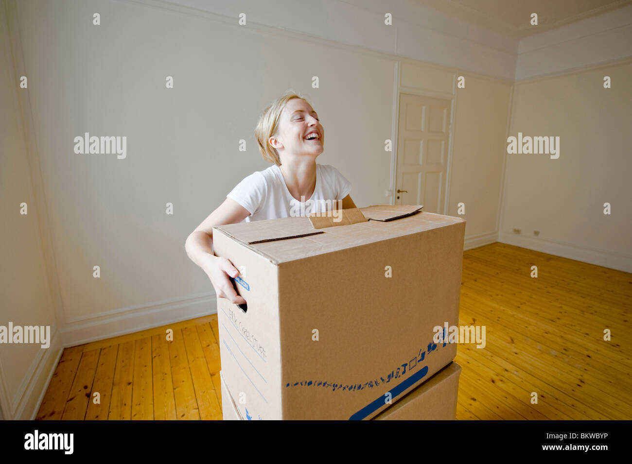 Donna di sollevamento scatola in movimento Foto Stock