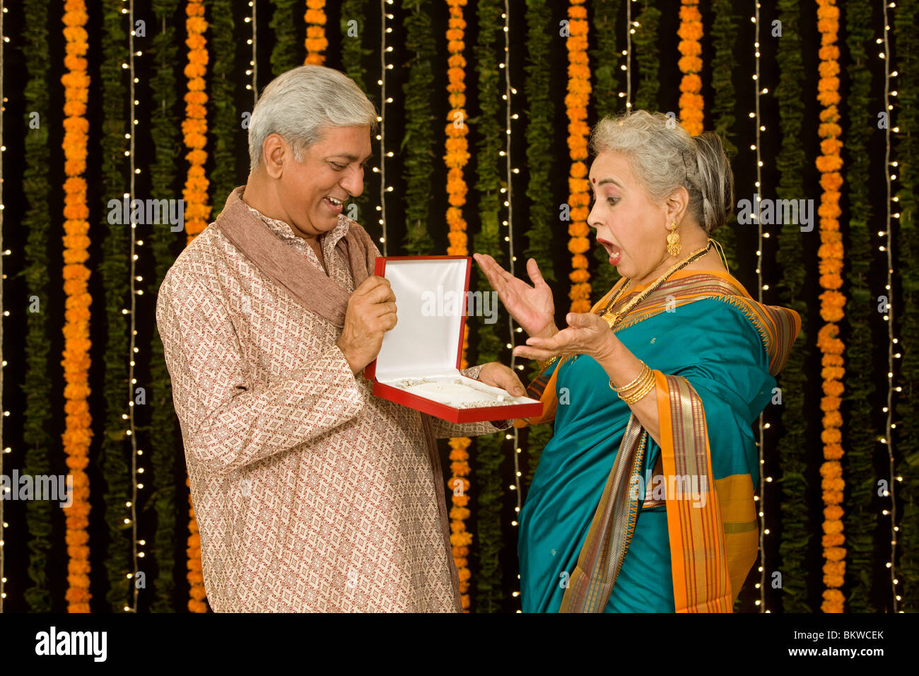 Uomo indiano dando una gioielleria per la moglie, donna sorpresa Foto Stock