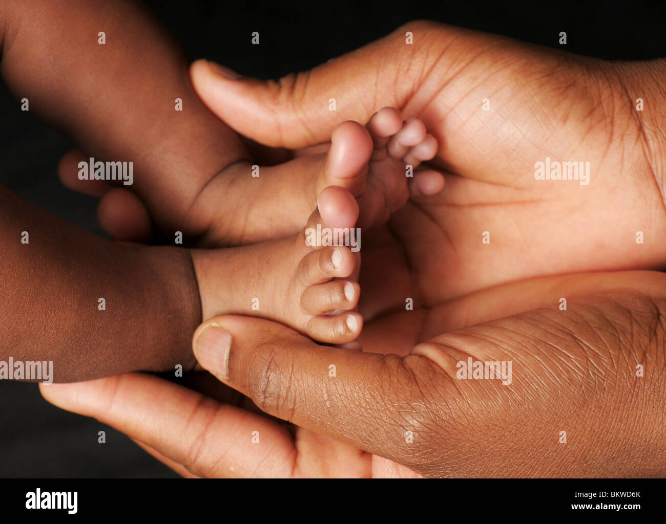 Una madre culle i piedi del suo bambino Foto Stock
