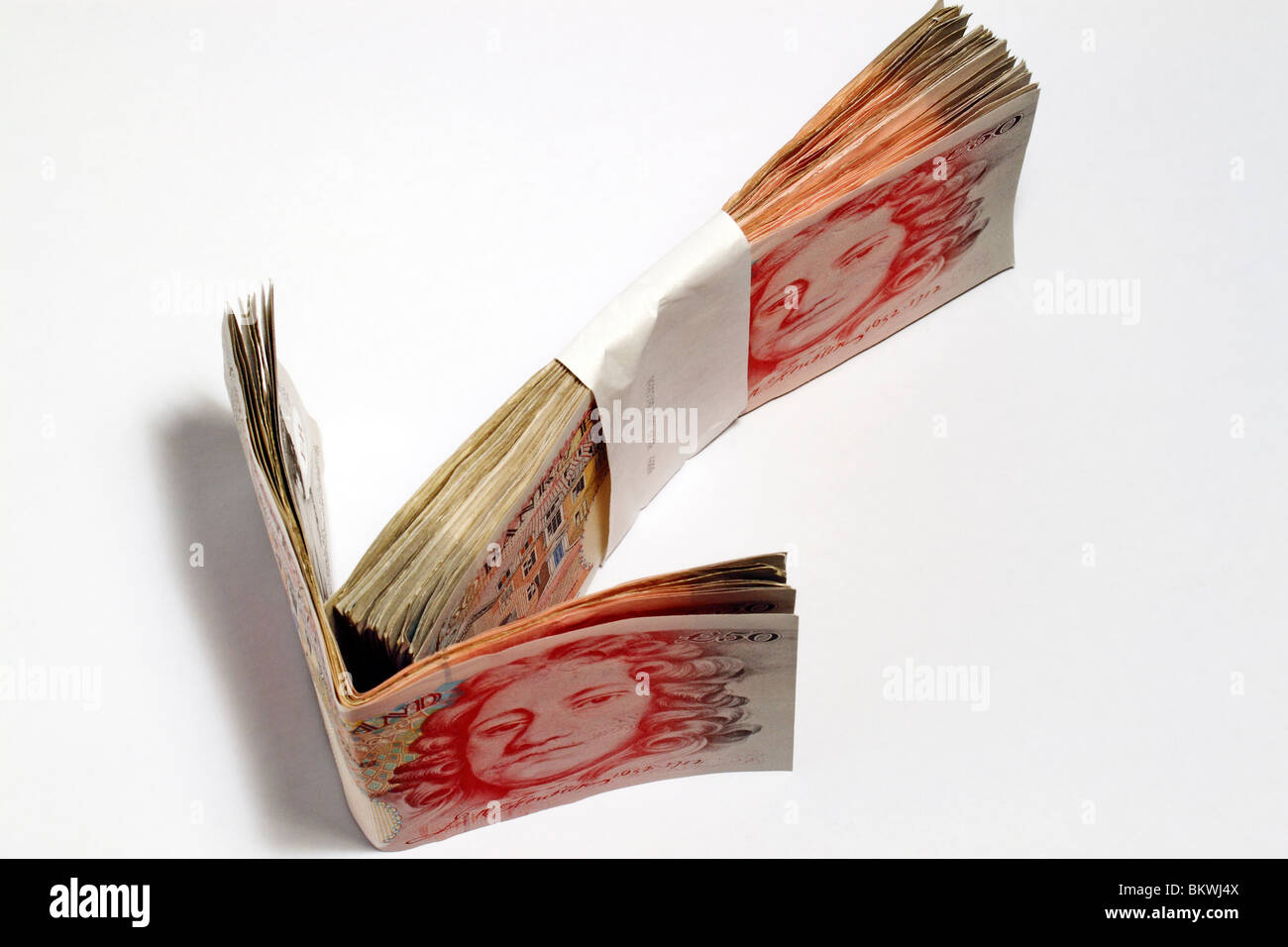 Un batuffolo di valuta britannica, Sterling Pound, disposte come una freccia. Foto Stock