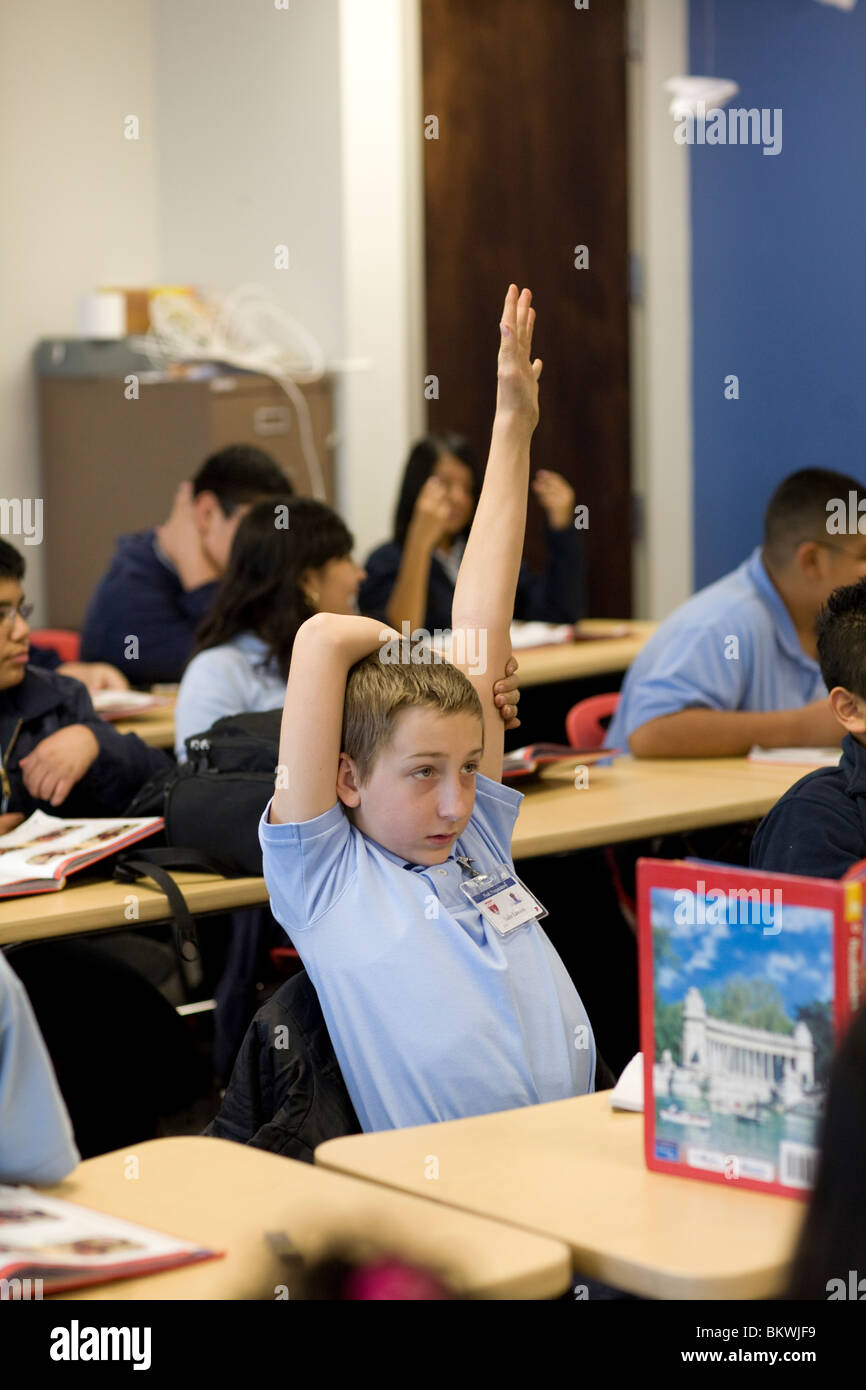 Centro scuola studente alza la mano nella sua classe di carta a scuola preparatoria di picco Academy a Dallas, Texas, Stati Uniti d'America Foto Stock
