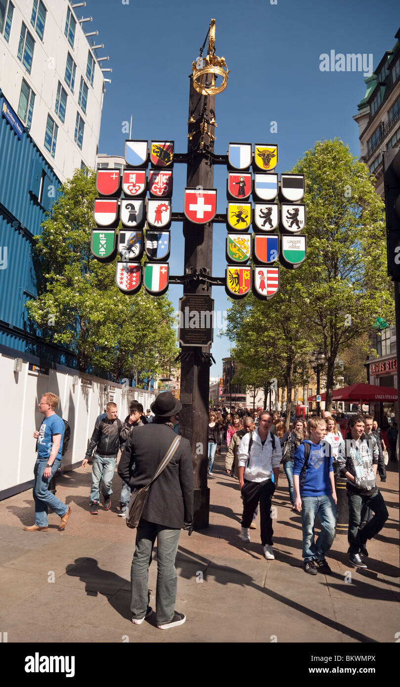 Un turista guardando gli emblemi di tutti i cantoni svizzeri, tribunale svizzero, il Centro svizzero, Leicester Square, London, Regno Unito Foto Stock