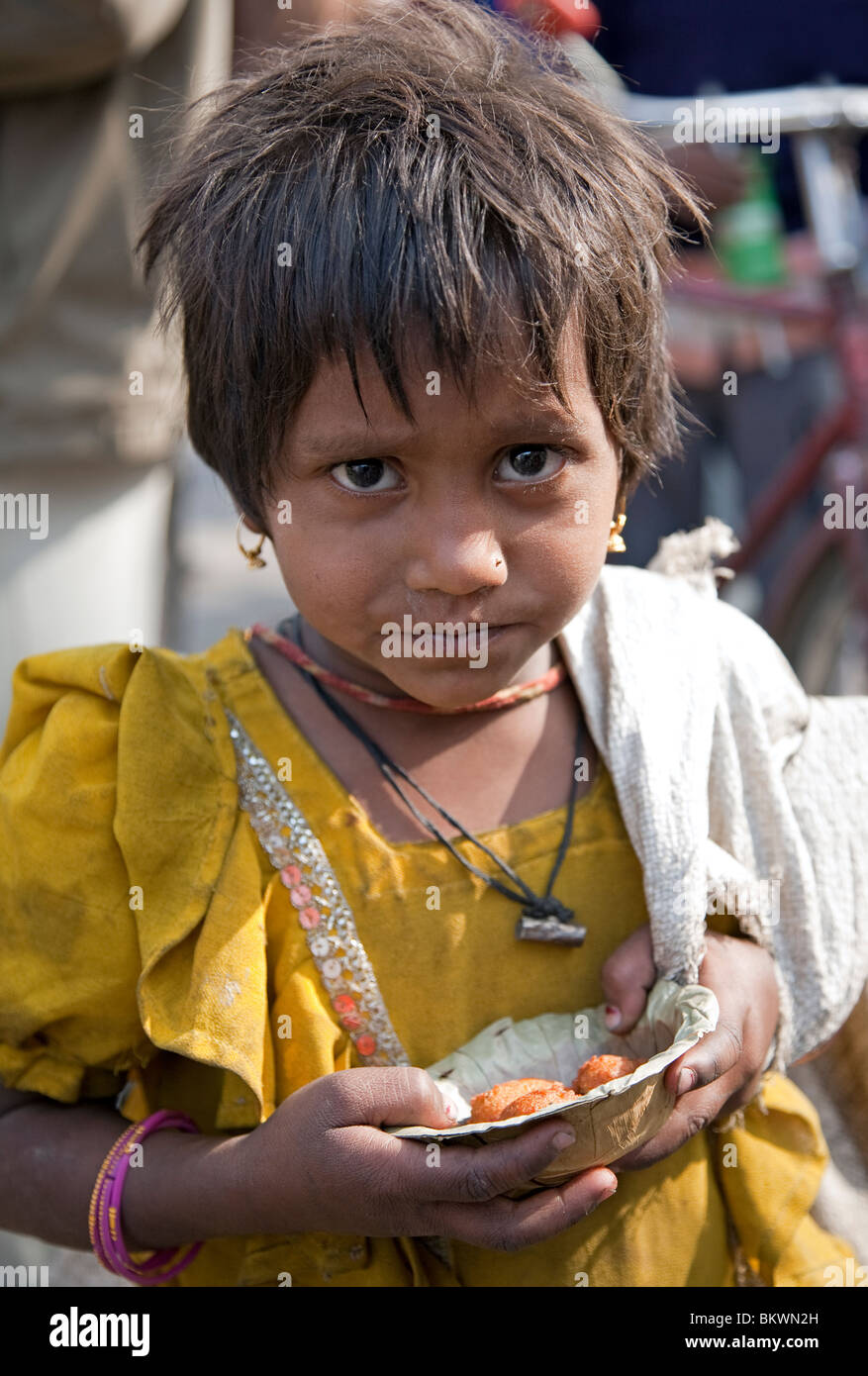 Poco mendicante pakoras mangiare. Jaipur. Il Rajasthan. India Foto Stock