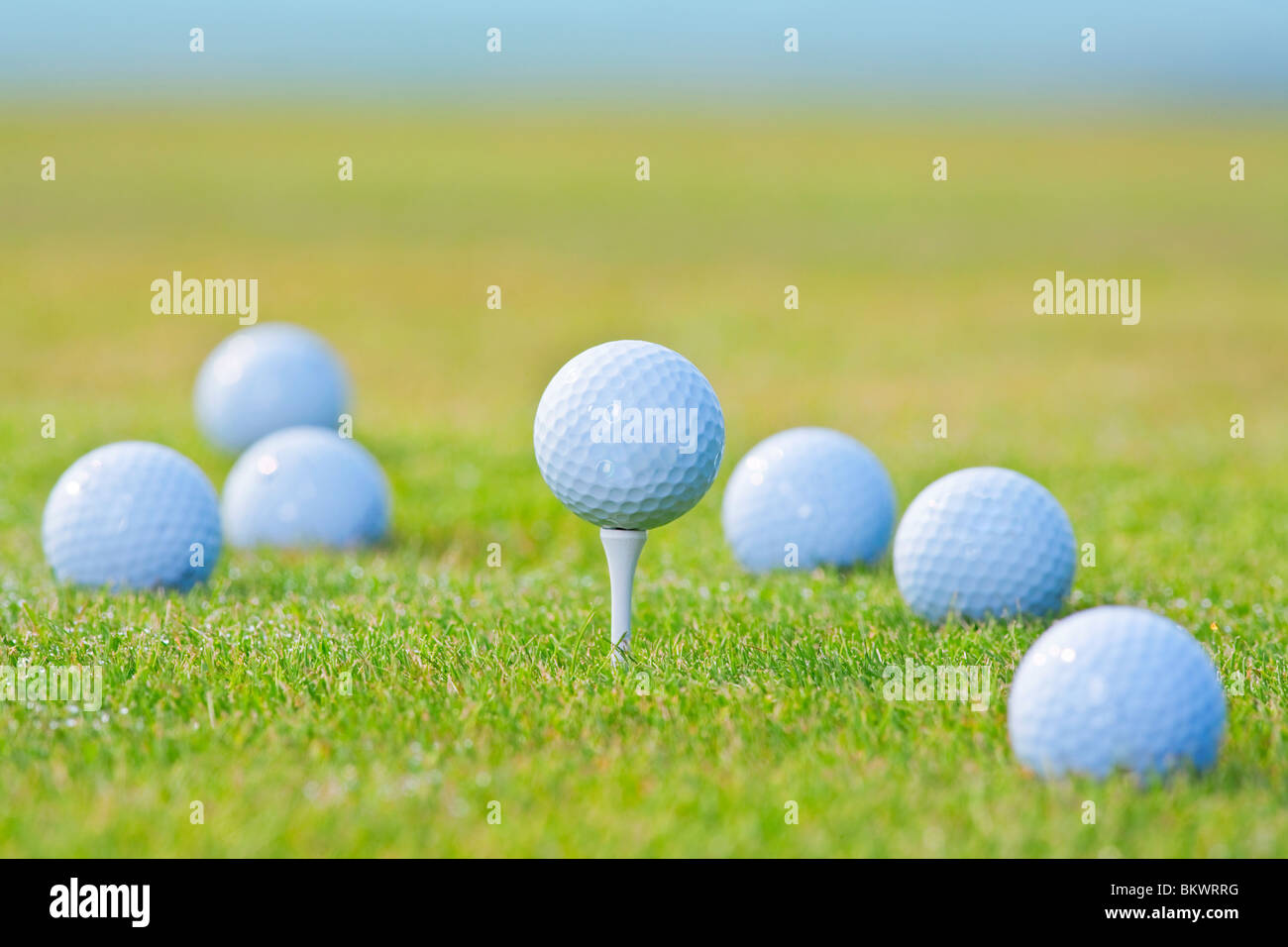 Palla da golf sul raccordo a t è circondato da altri palline da golf al di fuori della messa a fuoco Foto Stock
