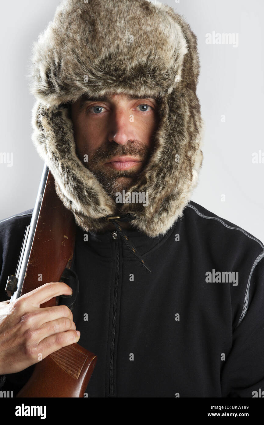 Hunter inverno cappello di pelliccia uomo ritratto tenendo la pistola Foto  stock - Alamy