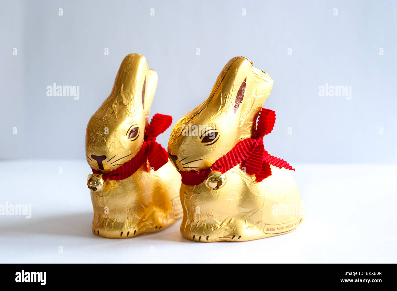 Il cioccolato conigli pasquali avvolto in foglia d'oro con un nastro rosso e un po' di bell Foto Stock