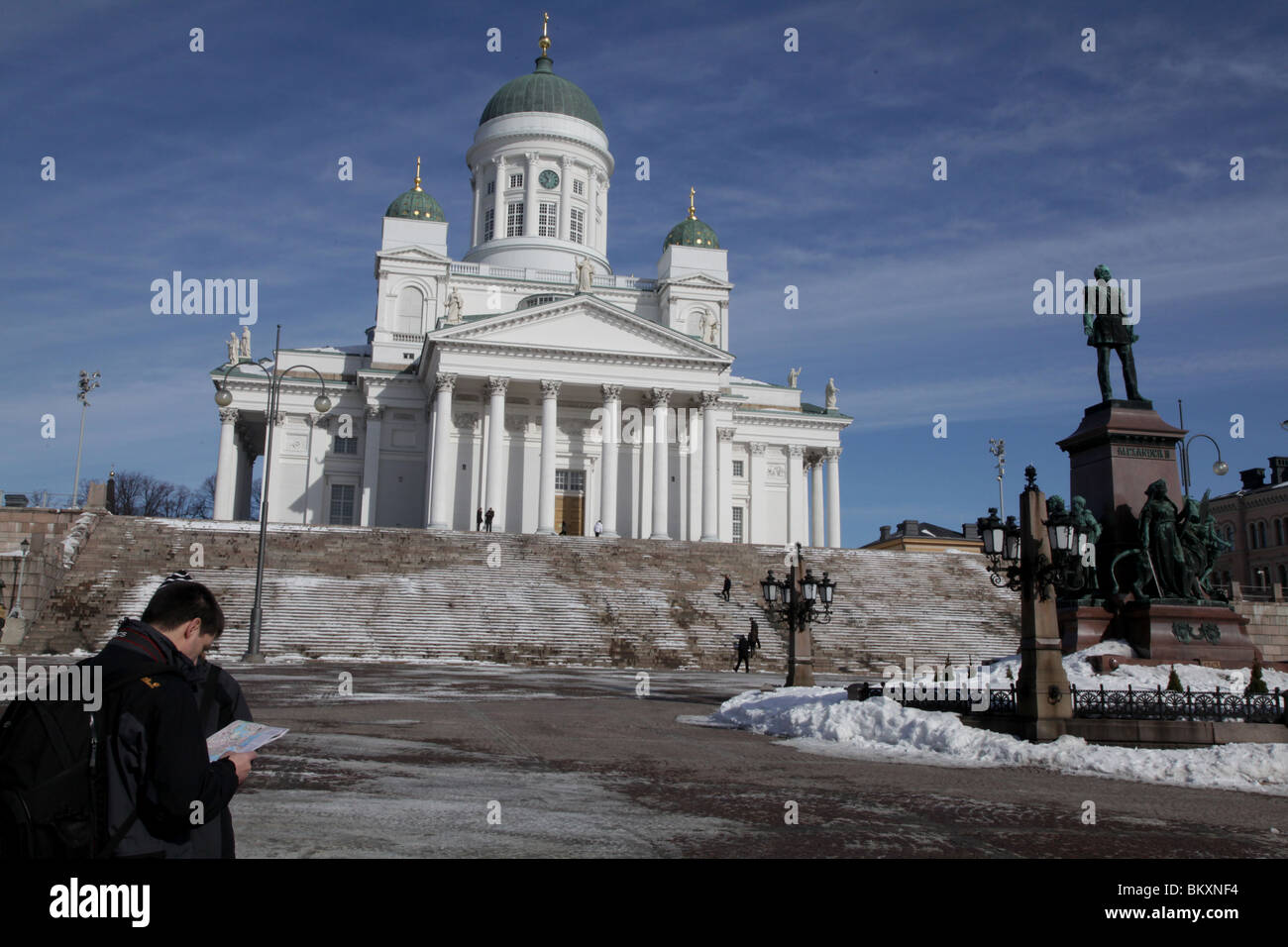 CATTEDRALE, TURISTI, MAPPA, HELSINKI: Turisti controllare leggere la mappa Helsinki Senate Square Cathedral Steps Snow Winter, Finlandia Foto Stock